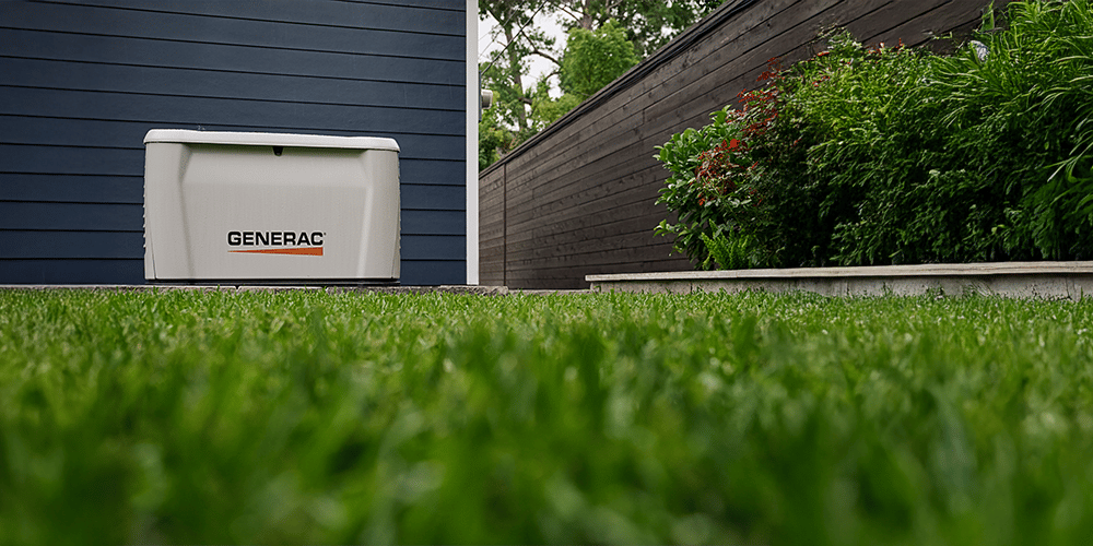 a generac home generator outside a home with a worms eye of grass.