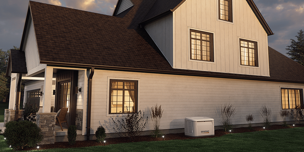 Home standby generator next to a suburban home with the lights on at dusk