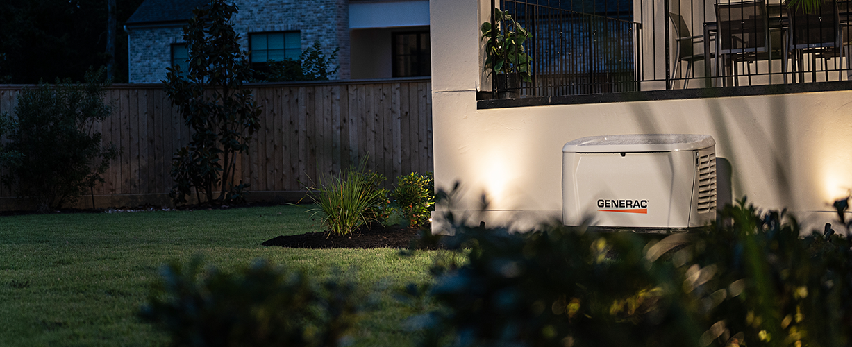 Generac home generator installed next to a home near some grass powering the electricity