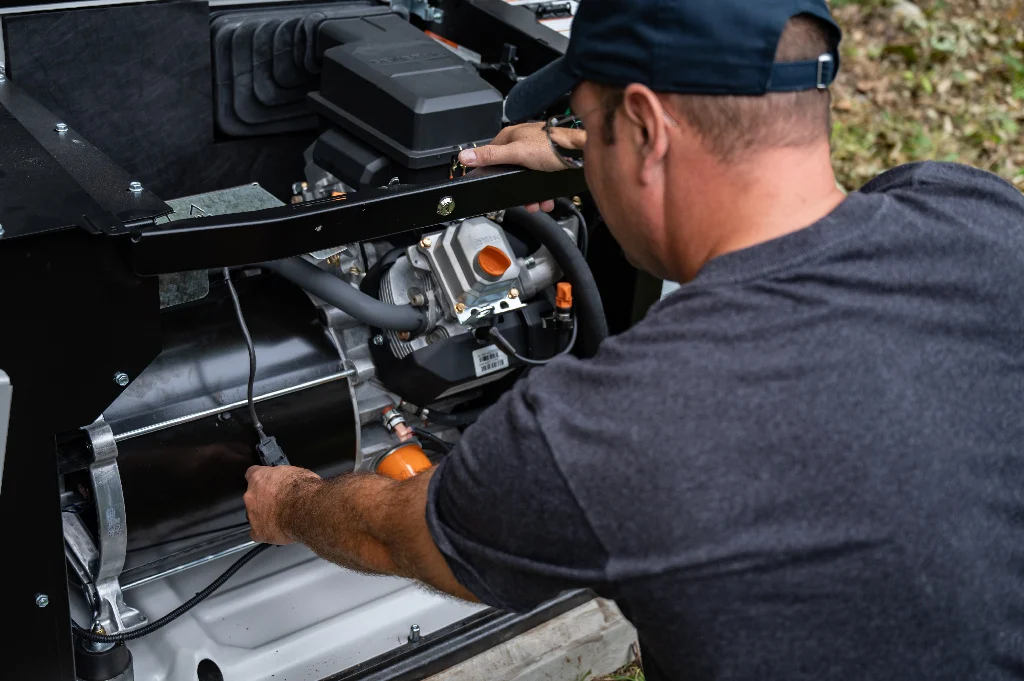 A generator with the lid open and a generac installer installing it