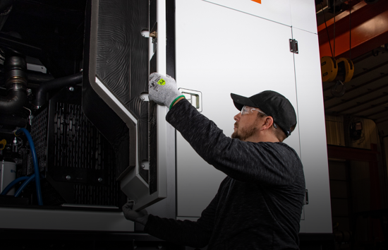 Technician performing routine maintenance on a Generac mobile generator. Access mobile generator manuals for service, troubleshooting, and dealer support.