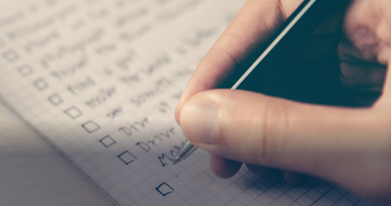 A person creating a checklist of home maintenance items