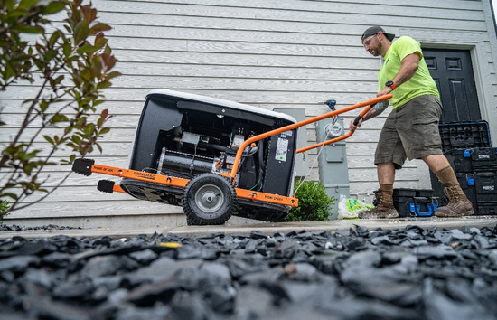 Generac dealer walking a disassembled home generator towards a house to install.
