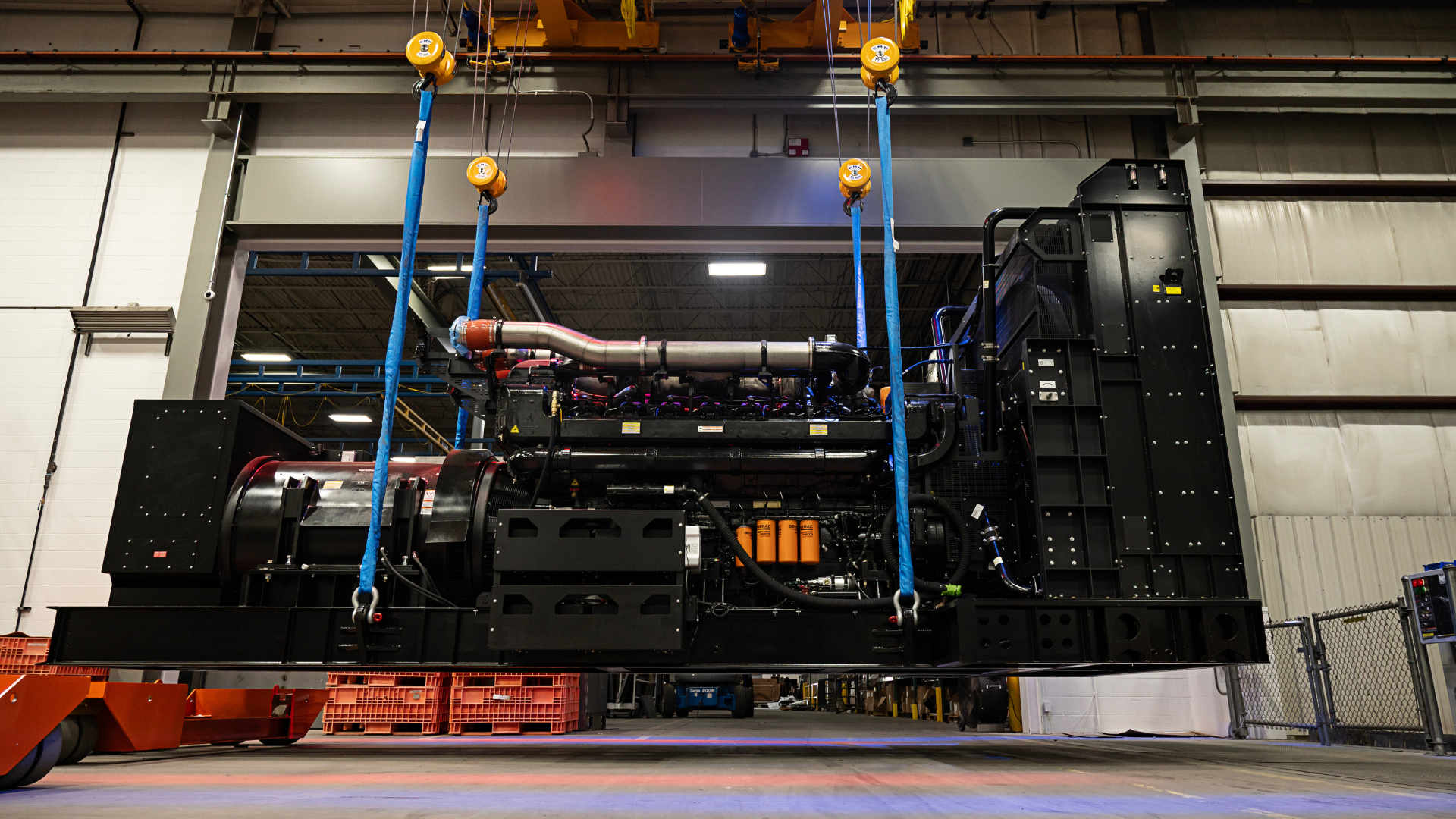 Generac Industrial Energy large megawatt data center generator hoisted to be put on a truck at a production facility
