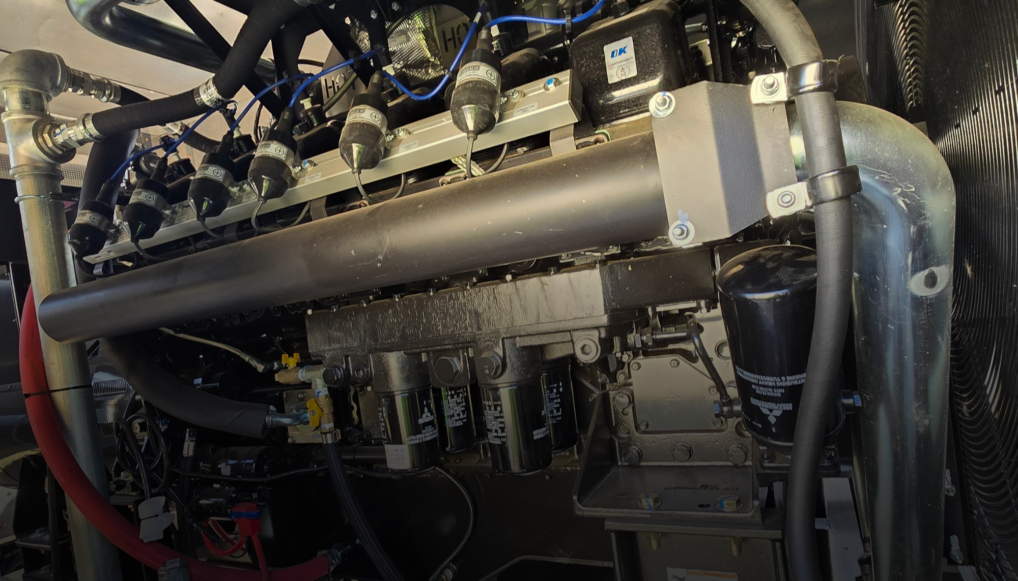 Close-up of a Generac industrial generator engine and fuel system components representing the different fuel options including diesel, natural gas, and Bi-Fuel™ solutions