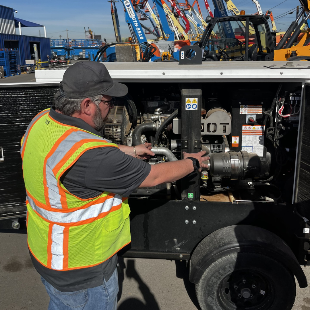 Generac technician in safety vest performing maintenance on an industrial generator showing our vast network of technical support.