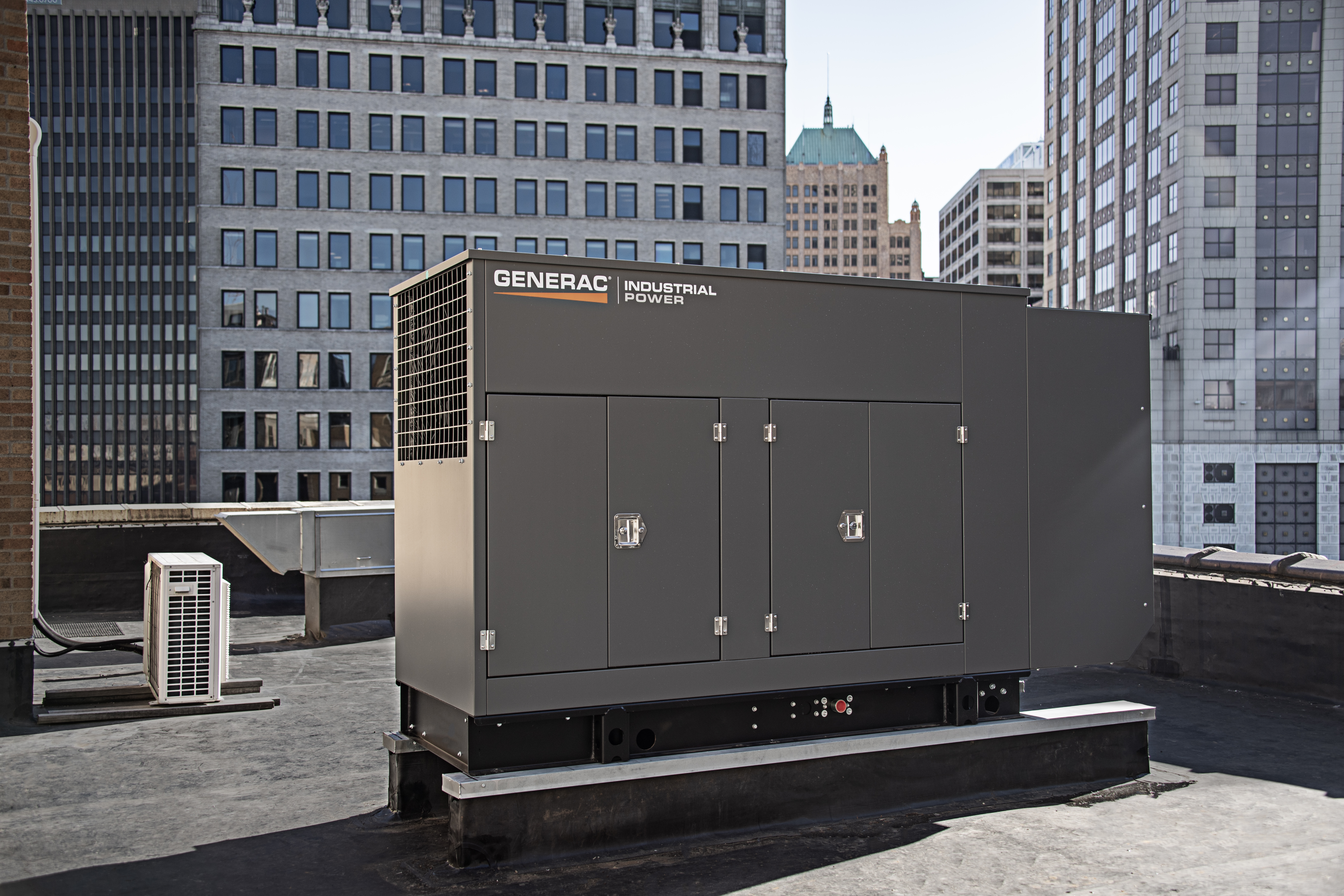  A dark gray Generac generator sits on a rooftop