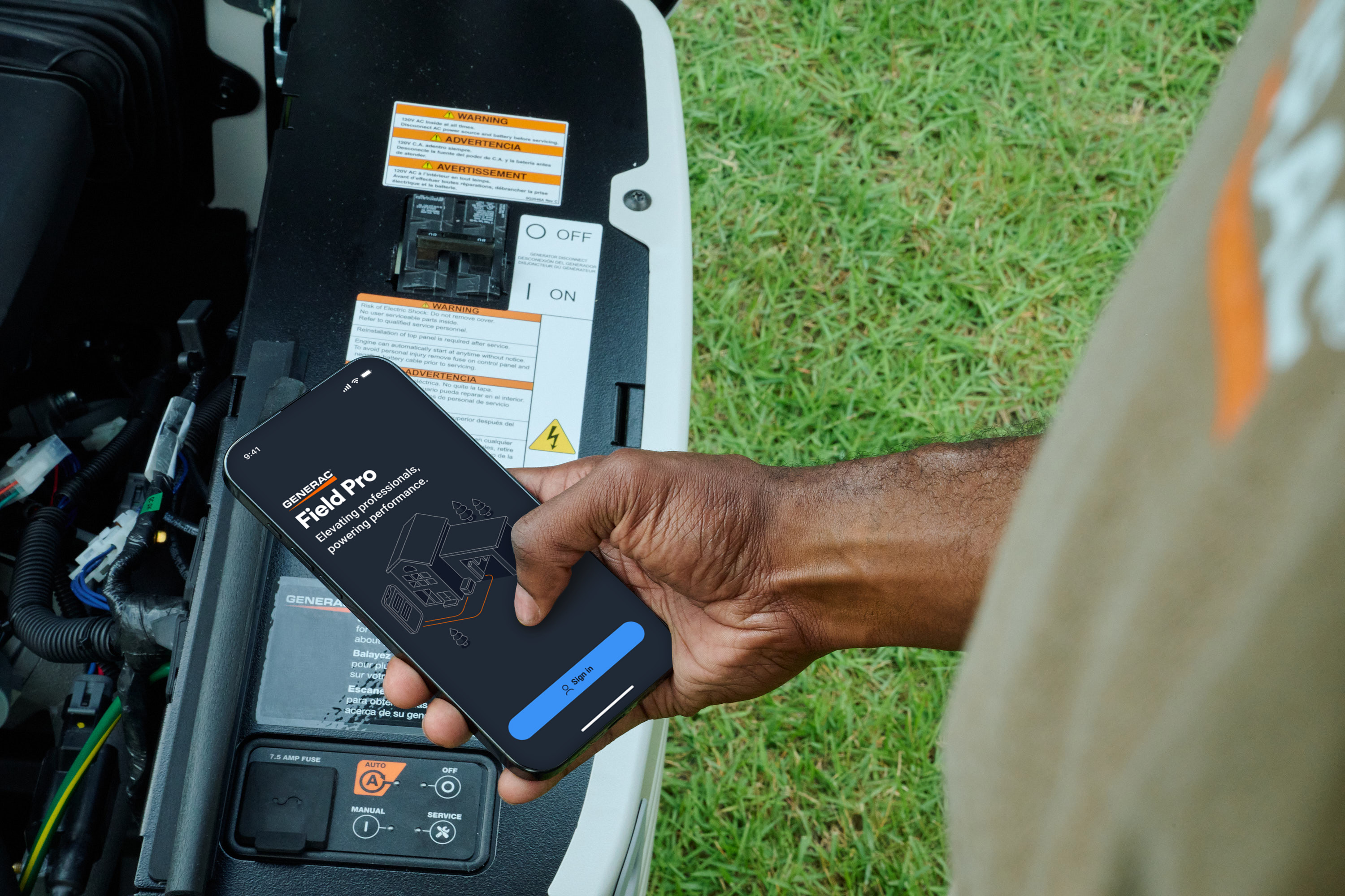 A technician holds a cell phone with the Field Pro App open near a home standby generator
