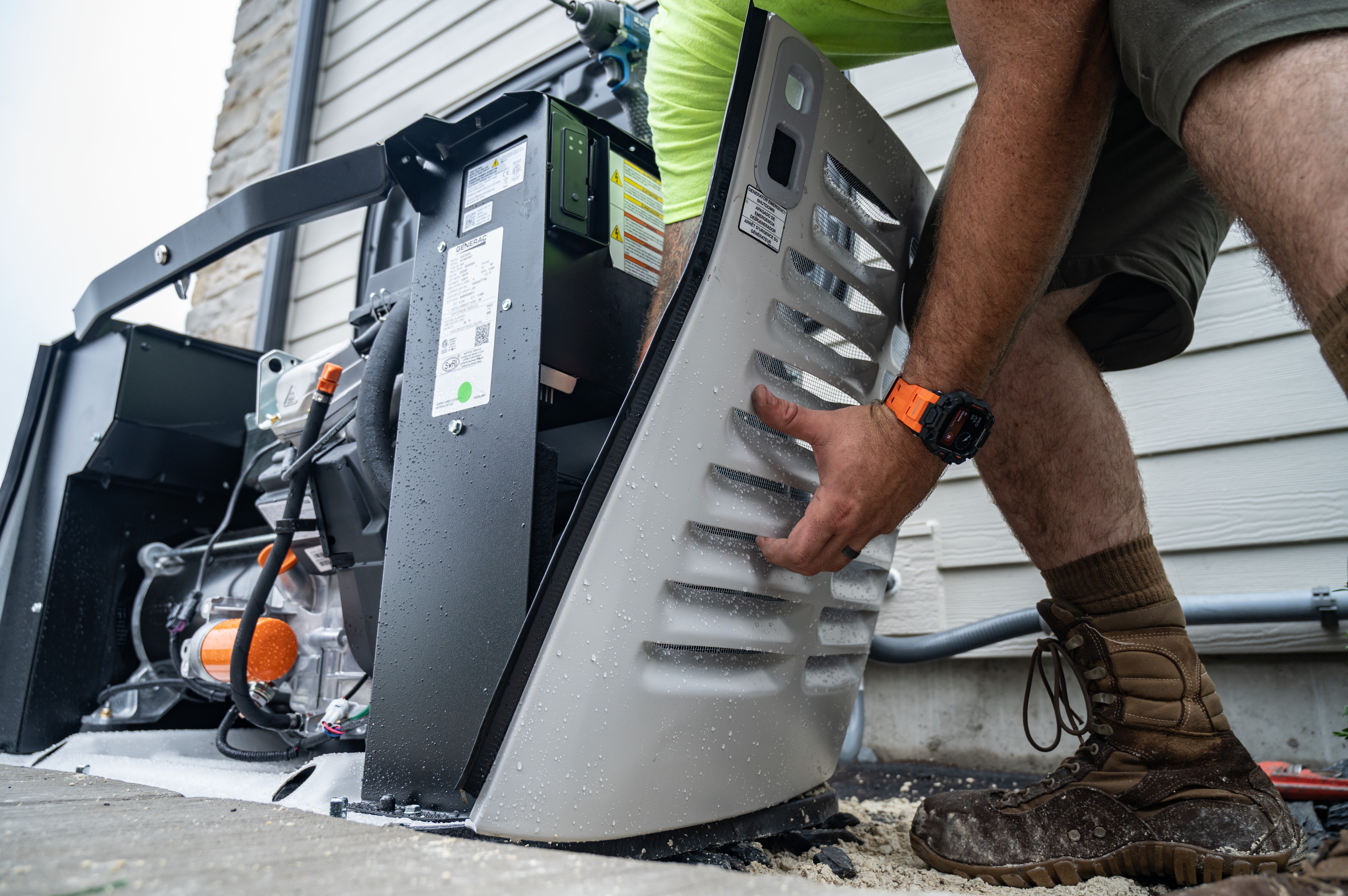 A technician installs a side panel to a Generac home standby generator