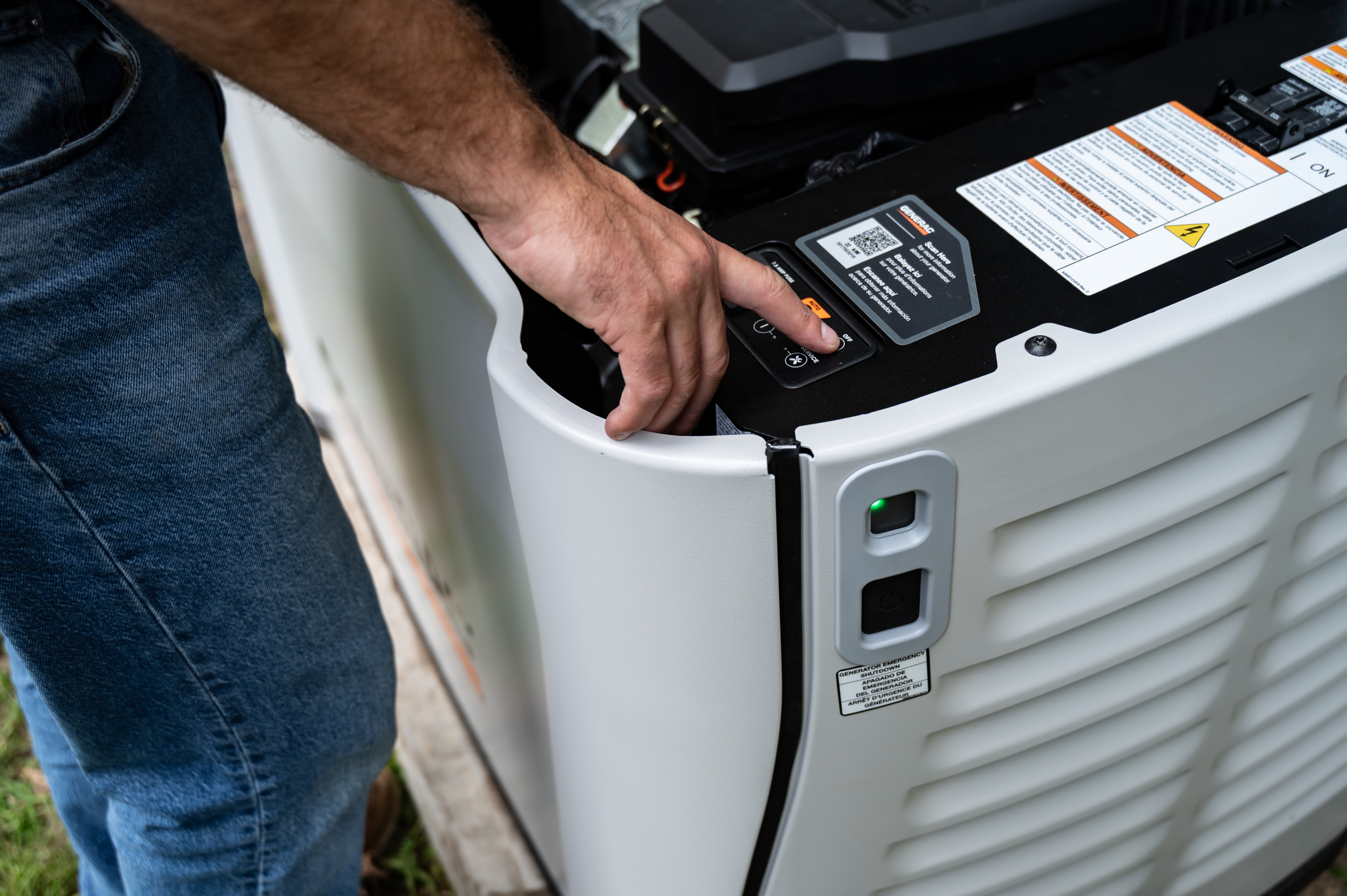 A technician pushes a button on a Generac home standby generator 