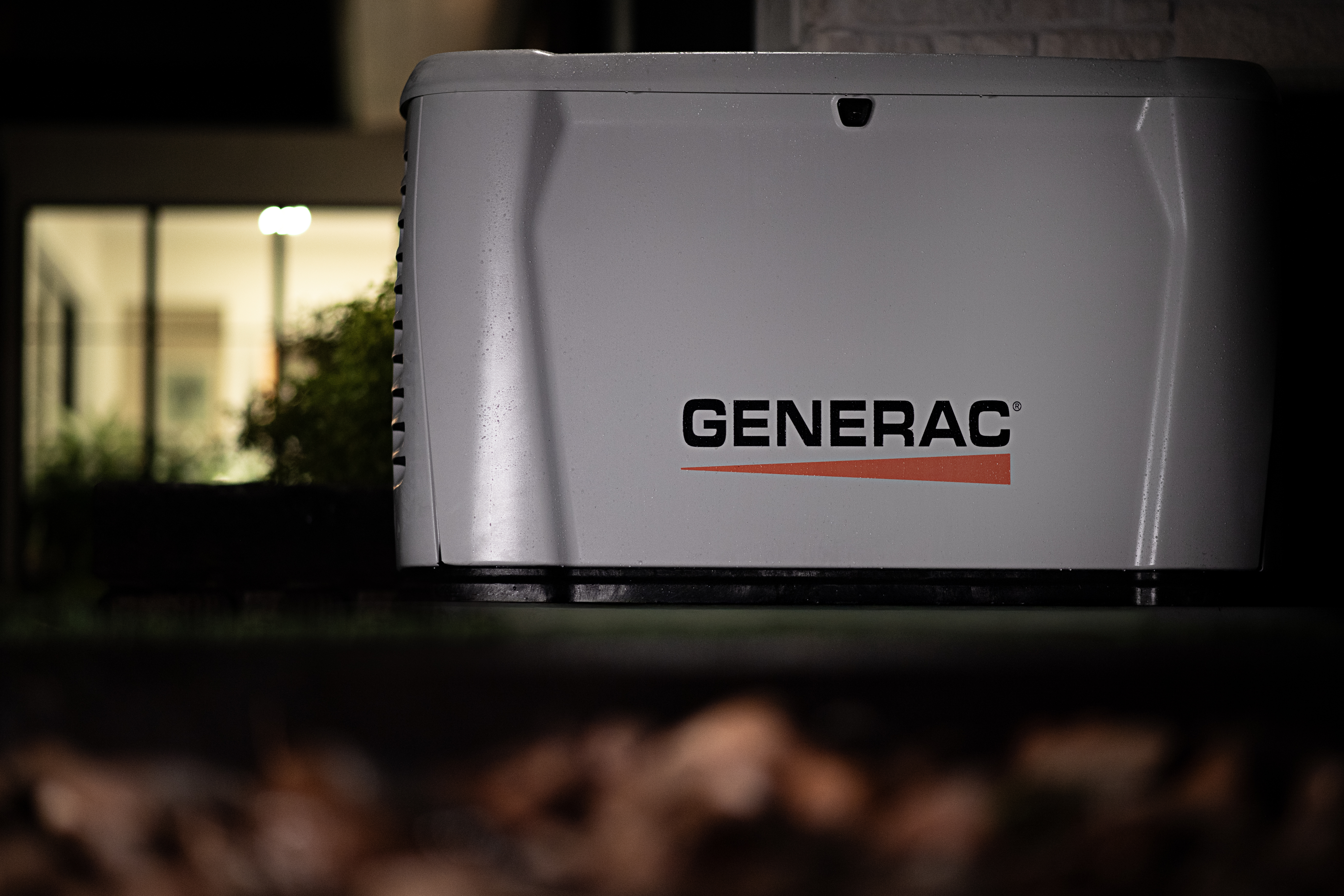  Generac home standby generator sits outside a home at night