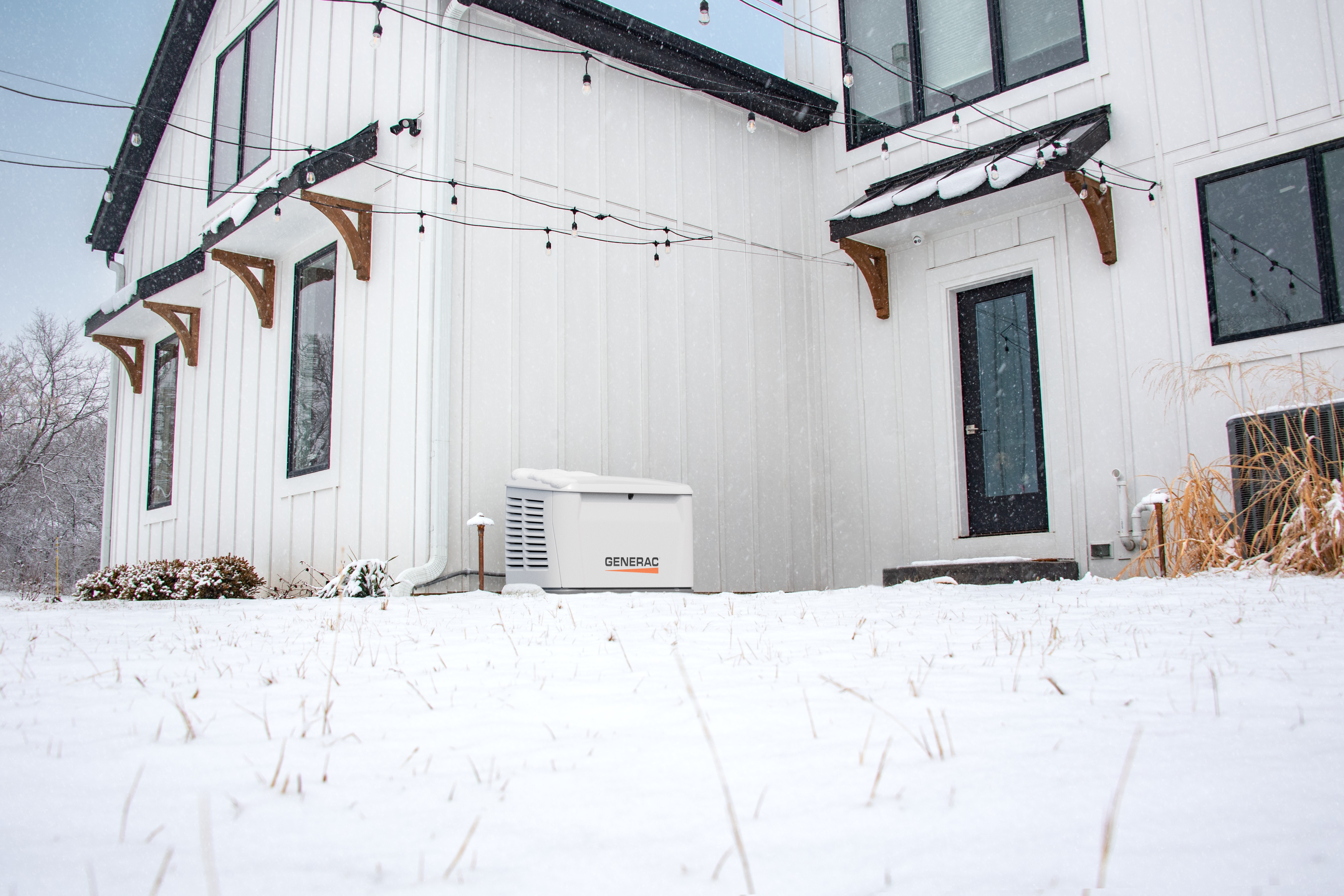Generac home standby generator sits outside a home in the snow