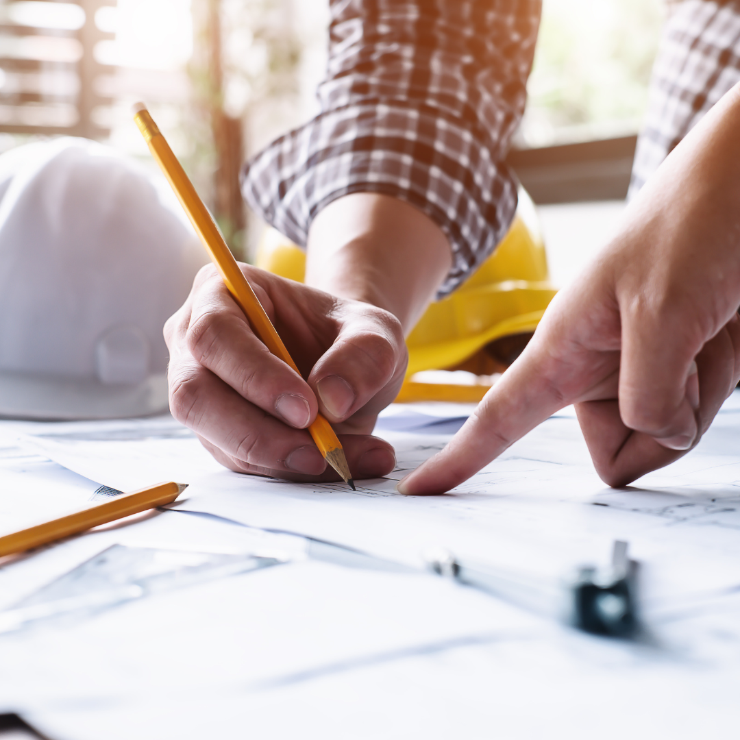 Engineers collaborating over blueprints, representing confident planning with Generac’s generator sizing tool, Power Design Pro™