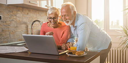 an older couple smiling at a computer in a shop