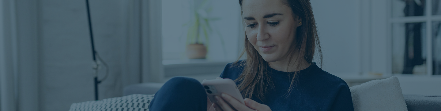 woman sitting on couch using a smart phone