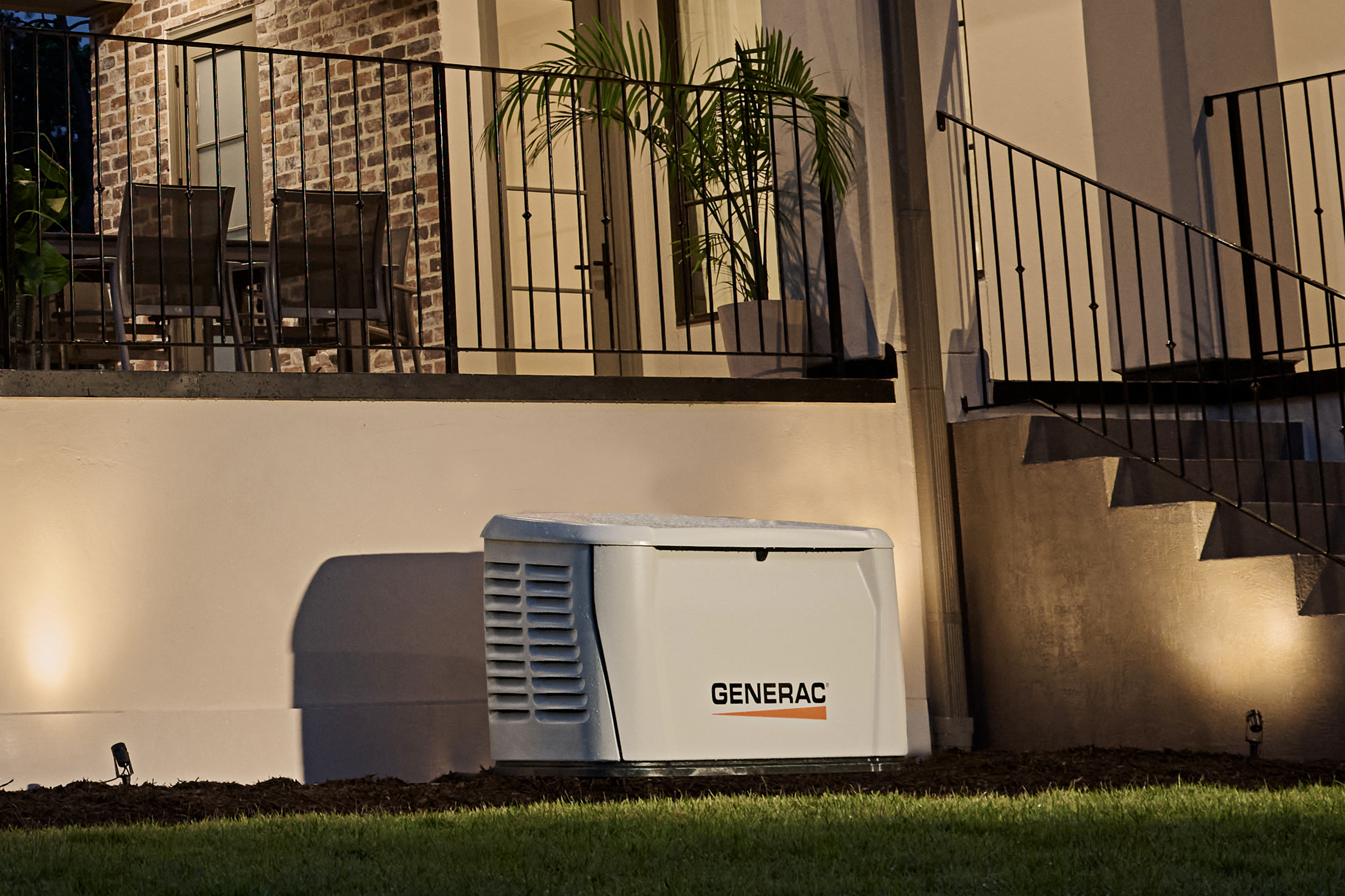 Generac home generator installed next to a home with the power on