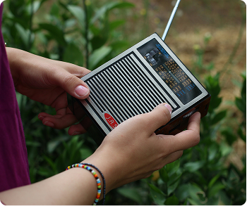 Portable hand-crank emergency radio being held outdoors