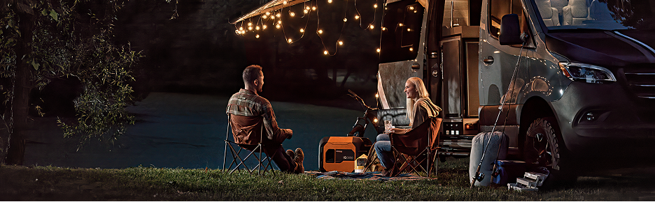 Couple camping with RV and portable generator at night