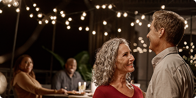a couple smiling at each other dancing.
