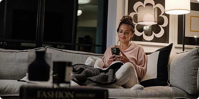 woman on smartphone sitting on couch