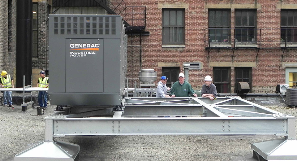 Construction workers outside a warehouse with a Generac generator.
